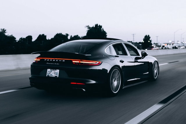 A black luxurious car moving on the road.