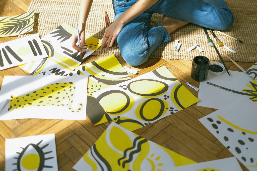 A woman painting on various sheets.