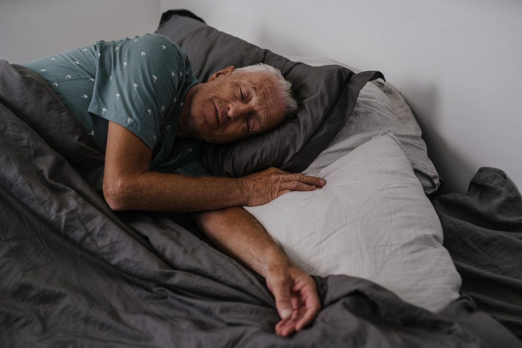 Man sleeping peacefully on the bed.