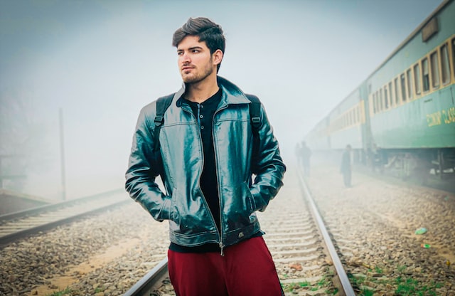 A man walking on the railway tracks.