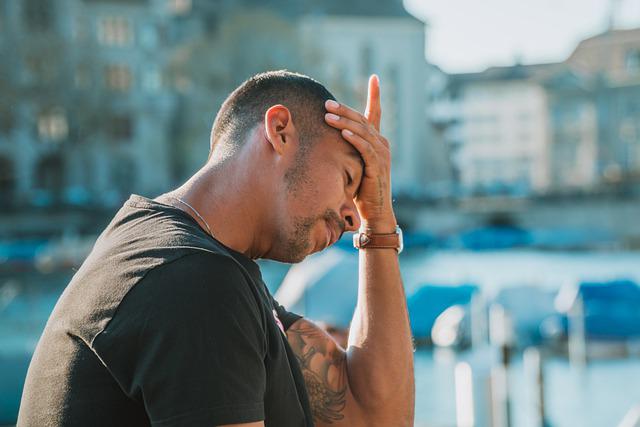 A man completely stressed out with his hand on his head.