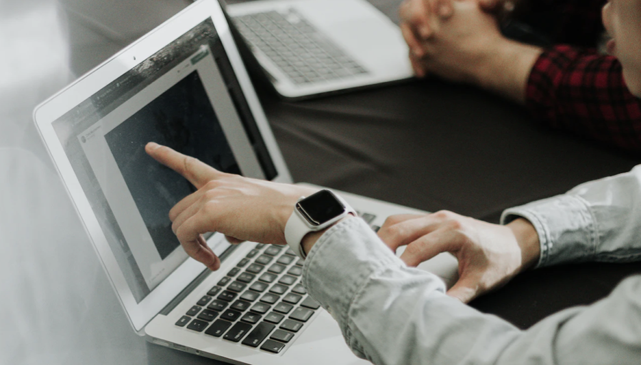 A man pointing out something on the laptop.