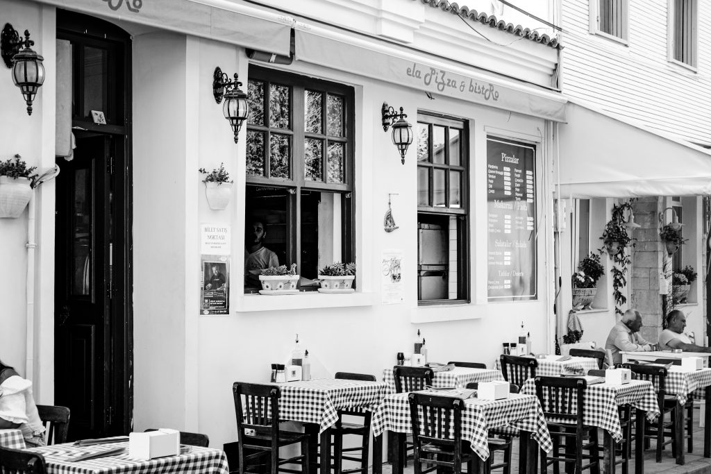 A white and black restaurant with black chairs.