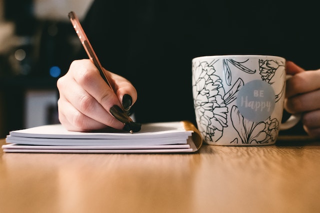 A woman writing in a book.